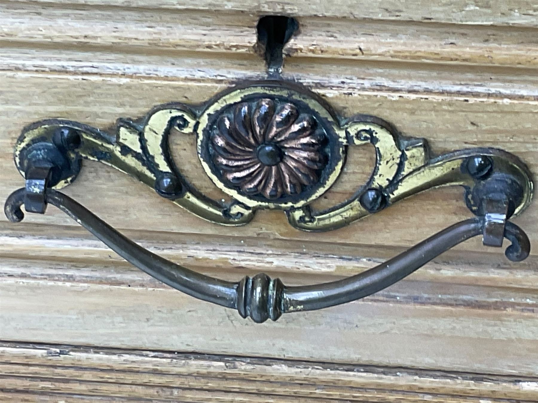 Late 19th century ash combination wardrobe, projecting cornice over foliage carved frieze, the left-hand upright enclosed by mirror glazed door, the right-hand side fitted with double panelled cupboard over two short and three long drawers, the upper panels carved with curled leaves and central scroll cartouche, on bracketed plinth 