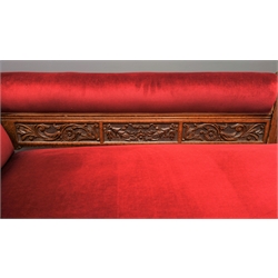  Edwardian oak chaise longue, back relief carved with scrolled foliage and flower heads, upholstered in red velvet, turned reeded supports, L175cm  