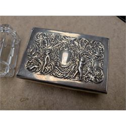 Two silver mounted boxes, including embossed example, decorated with cherubs, birds and scrolls, and a square glass example engraved with initials, both hallmarked 