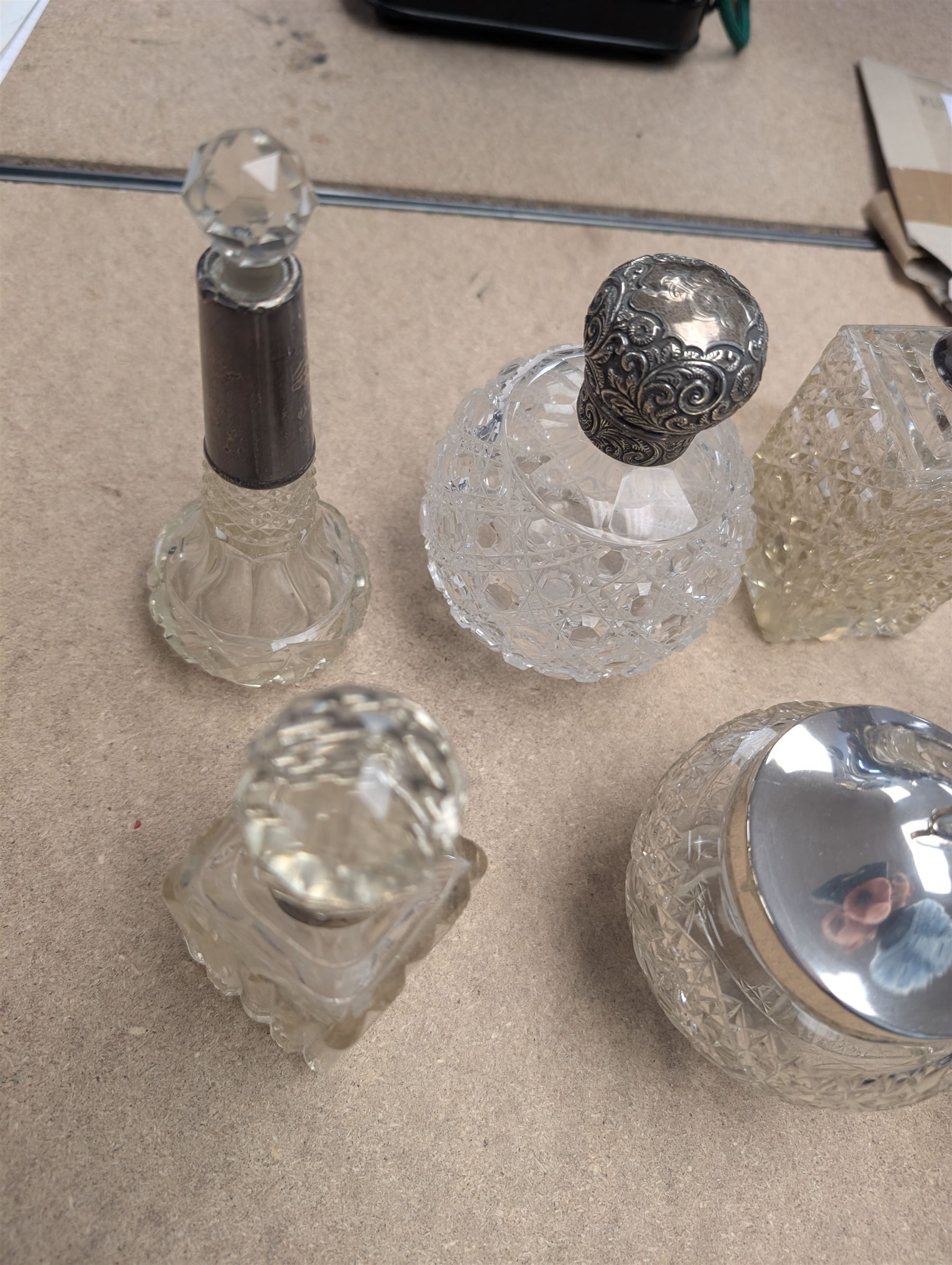 Collection of silver mounted glass bottles and jars, including decanter with etched floral decoration and silver collar, four scent bottles with silver caps, etc all hallmarked 