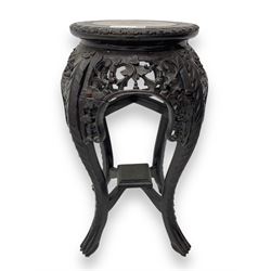 Late 19th century Chinese hardwood pedestal stand, circular top with inset marble panel, carved apron with openwork foliate and floral motifs, raised on cabriole supports with stylised claw and ball feet united by square undertier