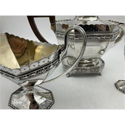 Victorian silver four piece tea service, comprising teapot, teapot stand, twin handled open sucrier and milk jug, each of octagonal form with foliate bud border and engraved decoration including crest to canted panels, and vacant panels, the teapot with ivory finial to the hinged cover and later wooden handle, hallmarked Edward Barnard & Sons Ltd, London1896, teapot including finial H15cm, milk jug including handle H16cm, teapot stand W11.5cm

This item has been registered for sale under Section 10 of the APHA Ivory Act