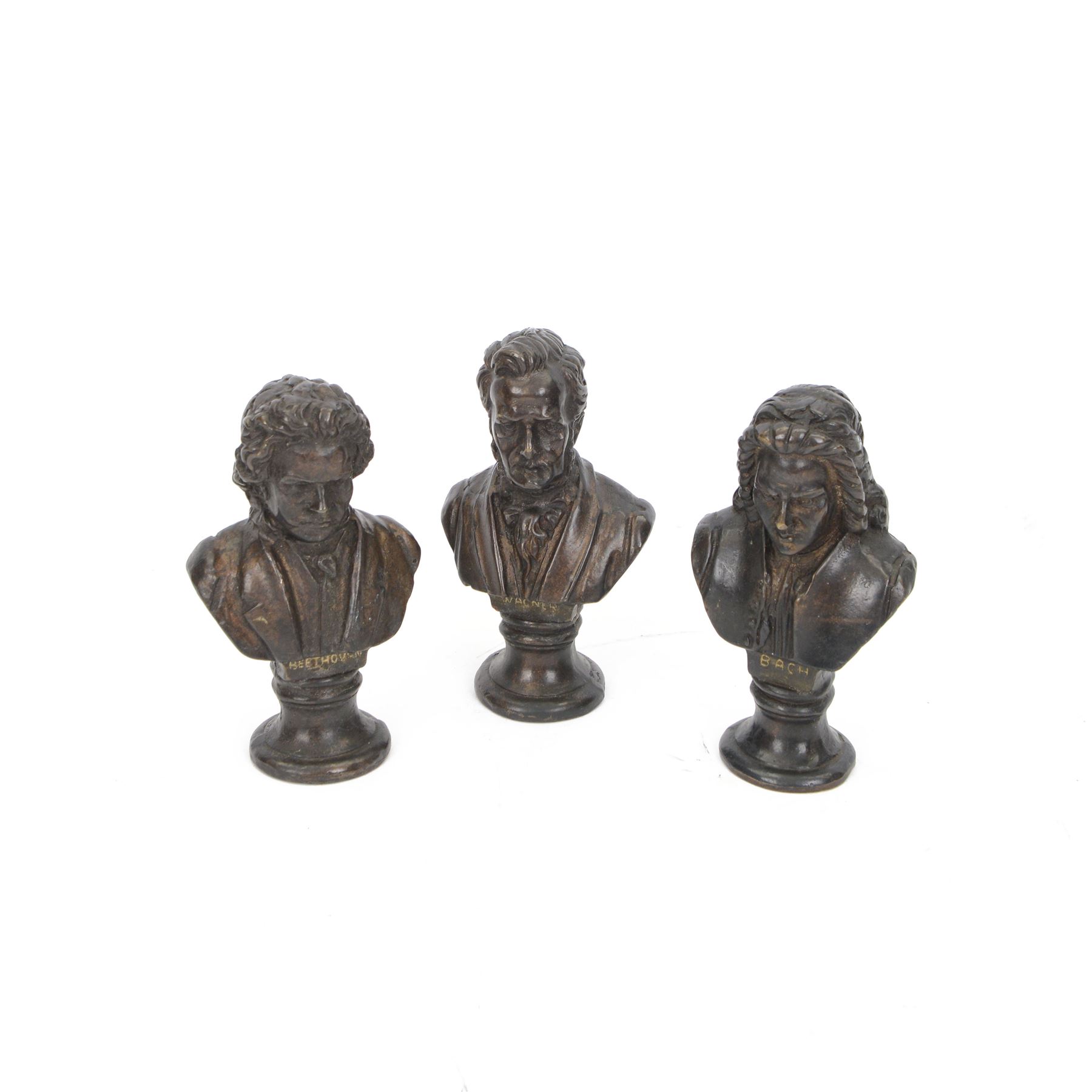 Three small bronze effect brass busts, modelled as composers Beethoven, Bach, and Wagner, each titled and raised upon a socle base, H14.5cm