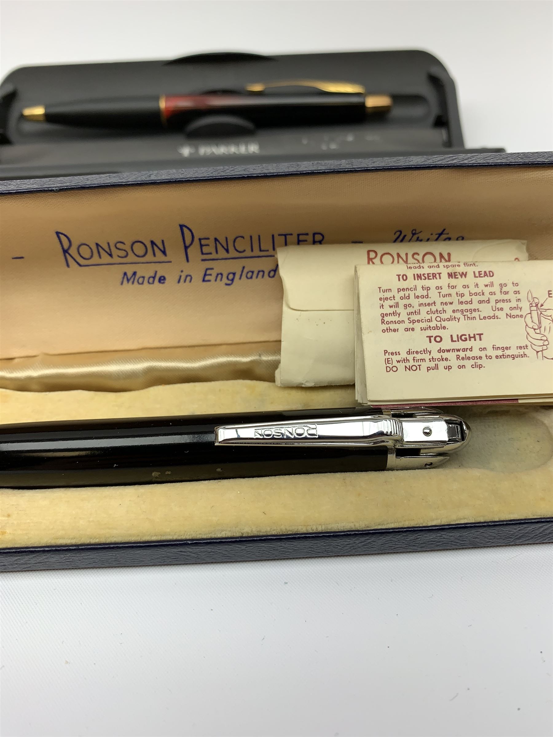 A group of pens, comprising Parker Duofold Centennial pearl and black ballpoint pen, Parker Frontier ballpoint pen, Ronson Penciliter, in original box, Parker Rialto fountain pen, and a further unmarked ballpoint. (5). 