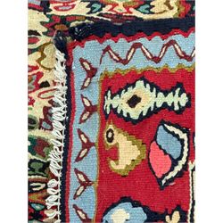 Senneh Kilim crimson ground rug, decorated with stylised plant motifs within overlapped lozenges, the border decorated with stylised motifs, within light blue guard stripe 