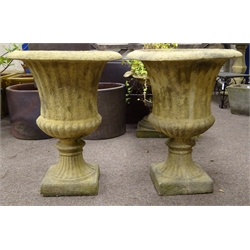  Pair of composite stone Campana shaped urns, reed and gardroon moulded bodies, on square section base, D59cm, H75cm  