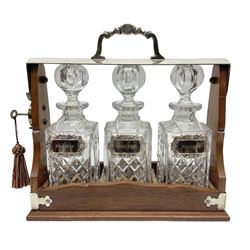 Edwardian silver plate mounted oak tantalus, containing three square sided cut glass decanters, complete with key, H33cm