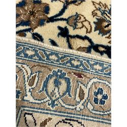 Persian ivory ground carpet, overall floral pattern with central rosette medallion, the field decorated with interlaced leafy branches and stylised plant motifs, guarded repeating border with repeating design