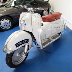 1957 Zündapp Bella R154 Scooter

• Registration: 150 KPU
• Year: 1957
• Model: Bella R154
• Engine: 150cc two-stroke single-cylinder petrol
• Transmission: Four-speed manual
• Odometer reading: 1,727 miles
• Colour: Ivory
• Seating: Dual seat
• V5C: Present
• Original registration book: Present
• Keys: 1

A characterful 1957 Zündapp Bella R154 scooter, finished in ivory with a contrasting brown dual seat and displaying an odometer reading of 1,727 miles.

The Bella R154 formed part of Zündapp’s distinctive range of German touring scooters, combining a 150cc air-cooled two-stroke engine with four-speed transmission, large wheels and substantial pressed-steel bodywork. This example retains its enclosed front apron, central headlamp, chrome handlebars, brightwork, period VDO speedometer and decorative Bella badging.

An operation and maintenance manual is include and accompanied by its V5C and original registration book from 1957.

This vehicle forms part of the Estate of the Late John Sills and is offered for sale by the Executors, confirming a genuine reason for sale.