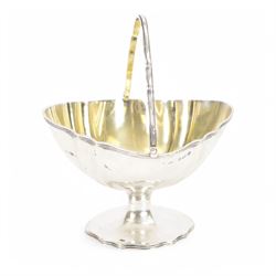 Early 20th century silver trinket box, of quatrefoil form, with shaped rim and engine turned decoration to cover, with vacant circular cartouche, hallmarked Deakin & Francis, Birmingham 1917 or 1942, H3cm, W8.5cm, together with an early 20th century silver swing handled sugar basket, with gilt interior, hallmarked Levi & Salaman, Birmingham 1918