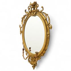 Late 19th century Louis XVI style giltwood and gesso girandole oval wall mirror, the oval frame surmounted with stylized urn finial and ribbon-tied garlands, laurel swags and rosettes, egg and dart decorated inner moulding and linked acorn outer moulding, flanked by intertwined foliate decorated candle branches 