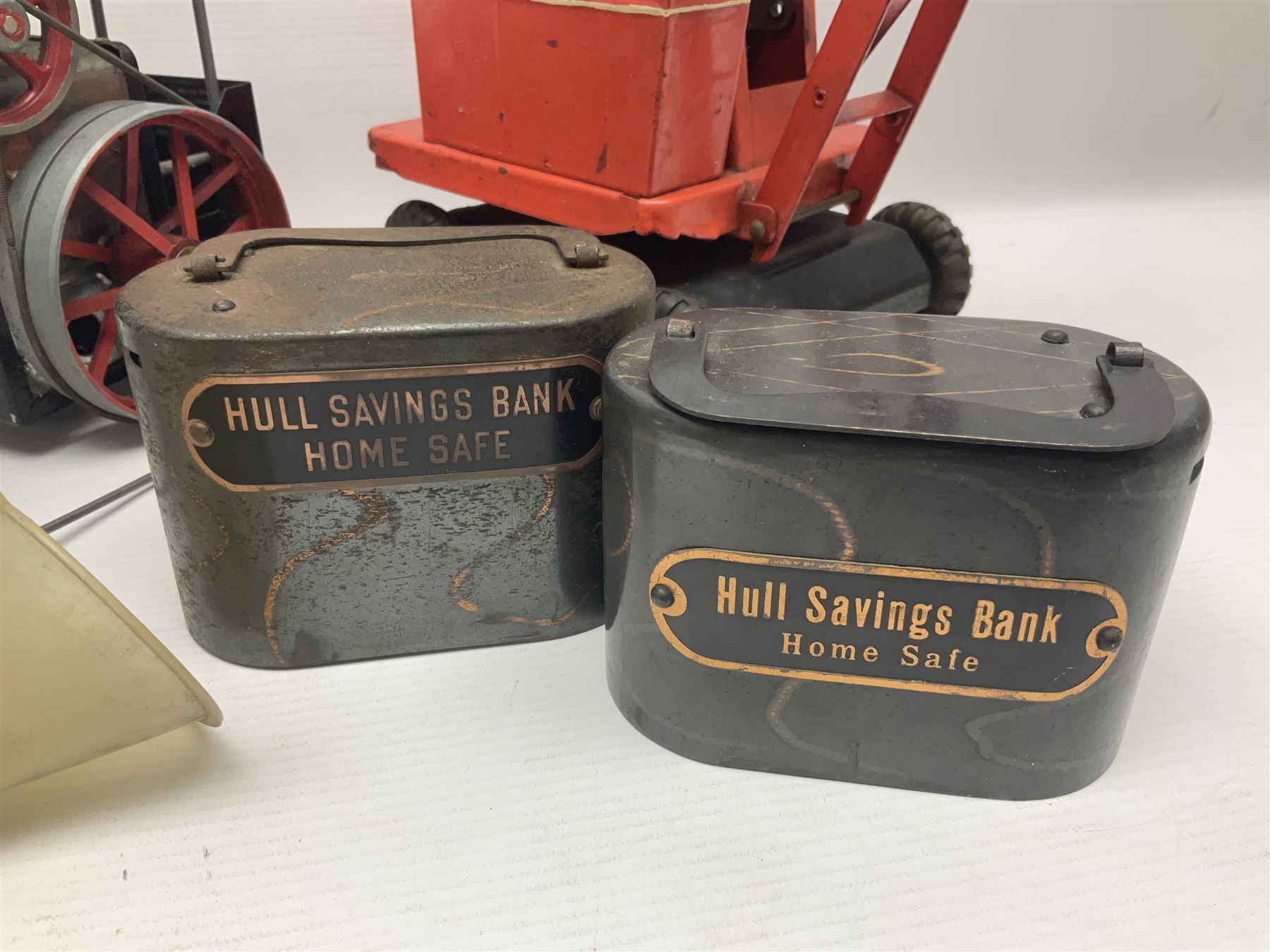 Mamod TE1a steam traction engine with burner, bunker, steering rod and funnel; red and black painted Tri-ang tin-plate Jones KL44 mobile crane; and two Hull Savings Bank Home Safe money boxes; all unboxed (4)