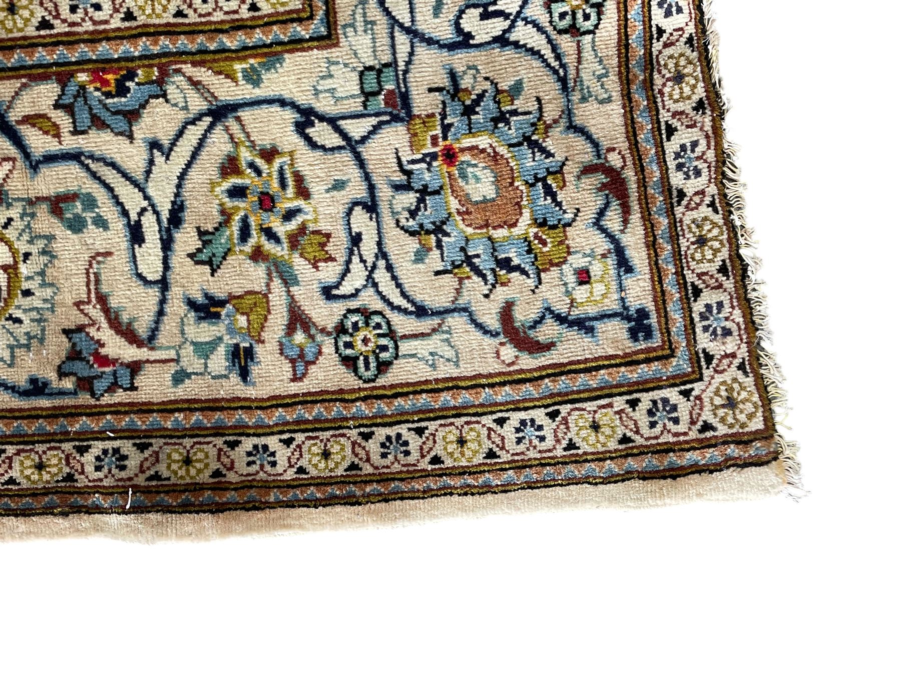 Persian Kashan ivory ground carpet, the field decorated with scrolling branches with foliate and palmette motifs, repeating border with stylised plant motifs, within floral and geometric pattern guard stripes 