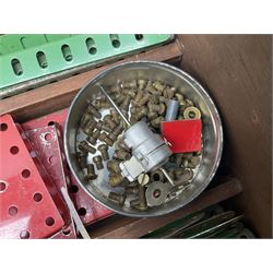 Meccano - large quantity of loose parts including various plates and strips, flanged plates, pulleys, axle rods and crank handles, wheels and tyres, gear wheels, brackets, nuts & bolts, various manuals; predominantly red and green; some in compartmentalised wooden trays