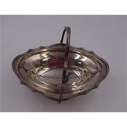 Edwardian silver swing handled basket, of oval form, with shaped reed rim and conforming swing handle, upon pedestal foot, hallmarked Goldsmiths & Silversmiths Co Ltd, London 1901, including handle H16cm