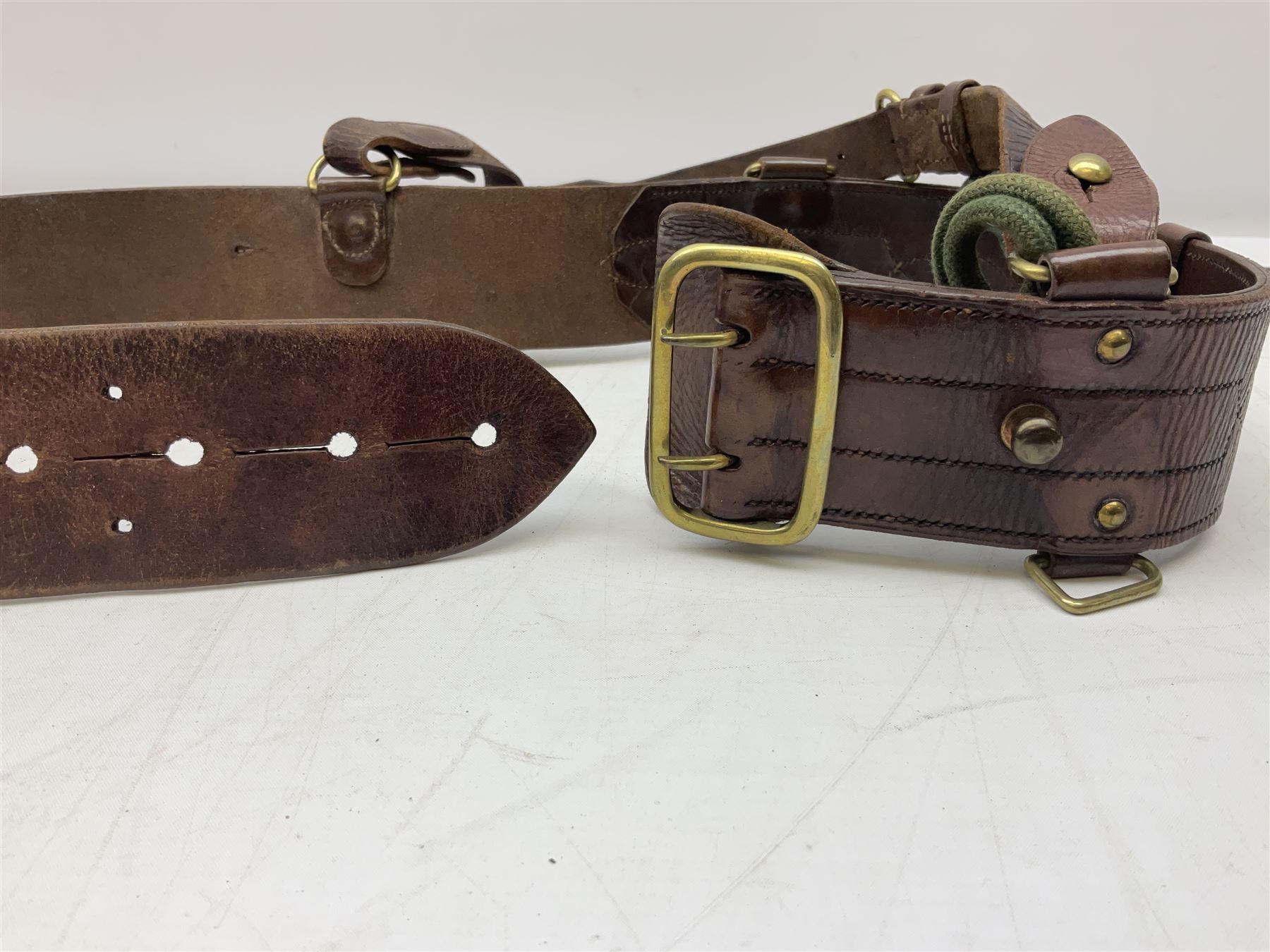 British Army Officers Sam Browne leather belt with shoulder strap; and webbing belt with Potter London Staybrite buckle for 19th Regiment of Foot (Green Howards) with various markings (2)