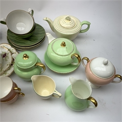  A Wedgwood bone china pink glazed teaset for six, comprising teapot, twin handled sucrier with cover, cream jug, milk jug, small bowl and plate, each with printed mark beneath. Together with a further Wedgwood green glazed part teaset, and other assorted tea wares, including a Newhall Nirvana shape teapot and jug, two lustre teacups with pierced saucers, three Narium teacups and saucers, etc., in wicker basket.   