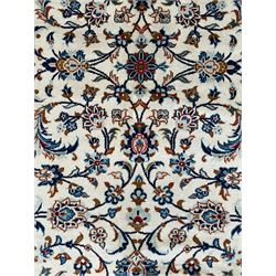 Persian Kashan ivory ground rug, decorated with curled leafy branches and palmettes, the border with scrolling design decorated with further palmettes, within floral pattern guard stripes