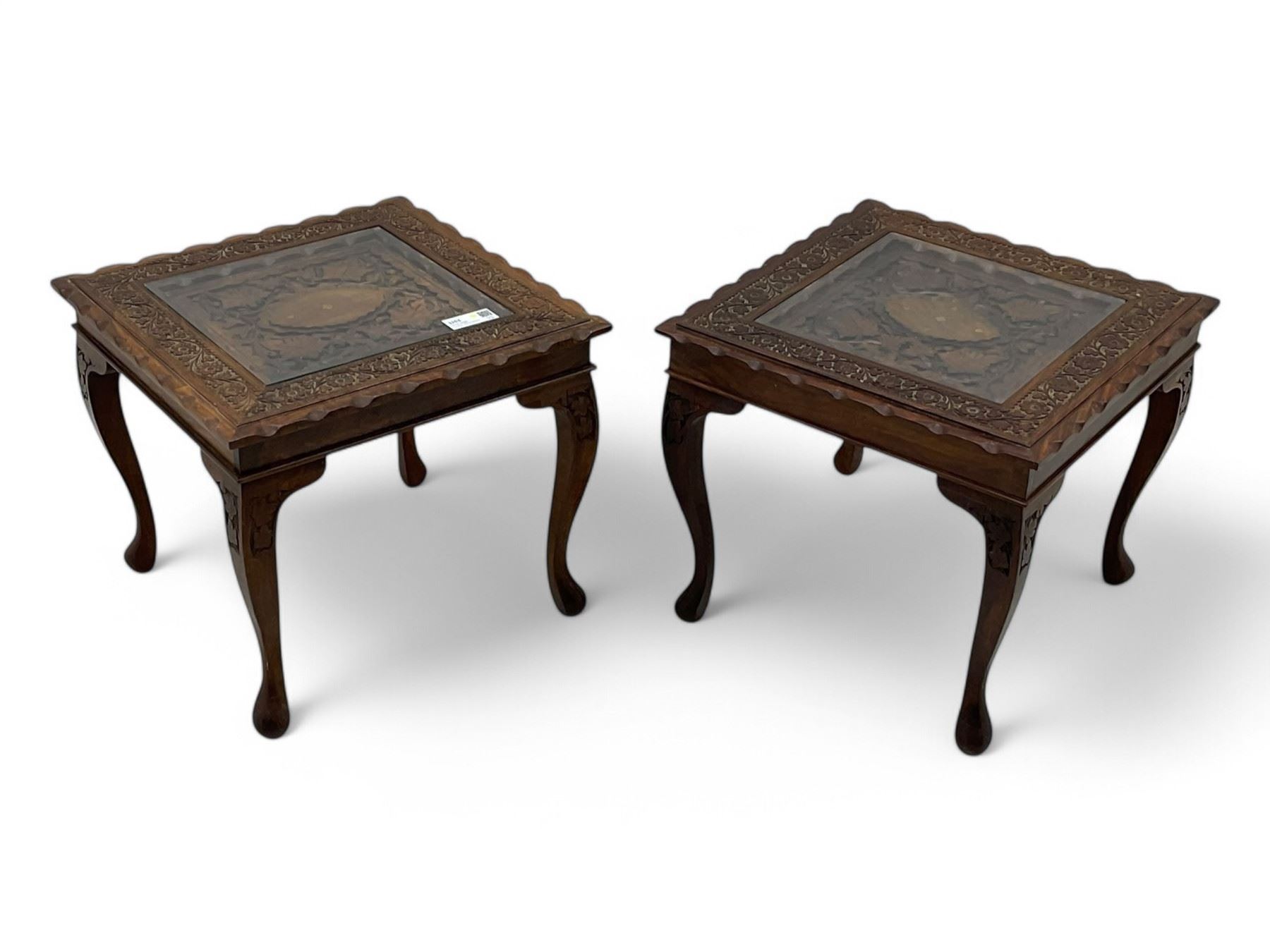 Pair of Pakistan carved hardwood brass inlaid lamp tables, square form, cabriole legs, inset glass tops