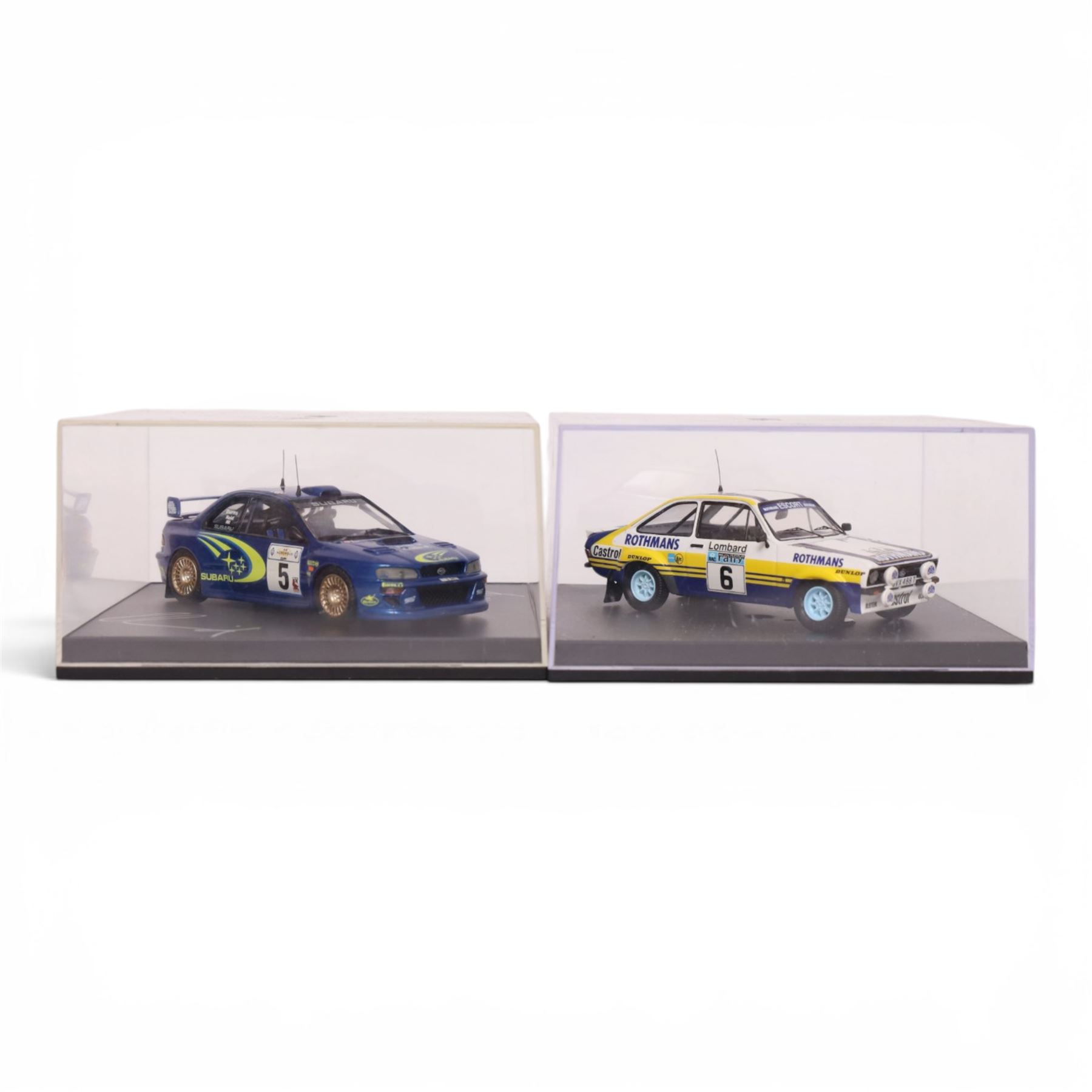 Four Troufeu 1:43 scale diecast model rally cars, including two limited edition Subaru's commemorating wins by Richard Burns, a Ford Escort RD 2000 and a Ford Escort Mk II, all in acrylic display cases