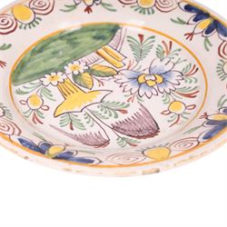 18th century Delft polychrome charger, decorated with a central landscape within a stylised floral boarder, D24cm 