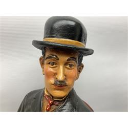 Large painted composite figure of Charlie Chaplin, seated upon wooden chair, H54cm