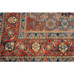 Persian indigo ground Herati rug, the busy field with a central lozenge pole medallion surrounded by repeating Herati motifs, within a shaped spandrel border the crimson guard band decorated with repeating palmette motifs