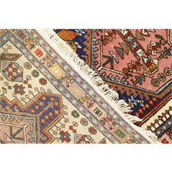 Persian Iranian wool runner, with a series of stepped hexagonal medallions in rust, olive and ivory against and deep navy field, the medallions are filed with floral and latch-hook motifs, framed by and ivory guard border with geometric rosettes, flanked by a rust outer band