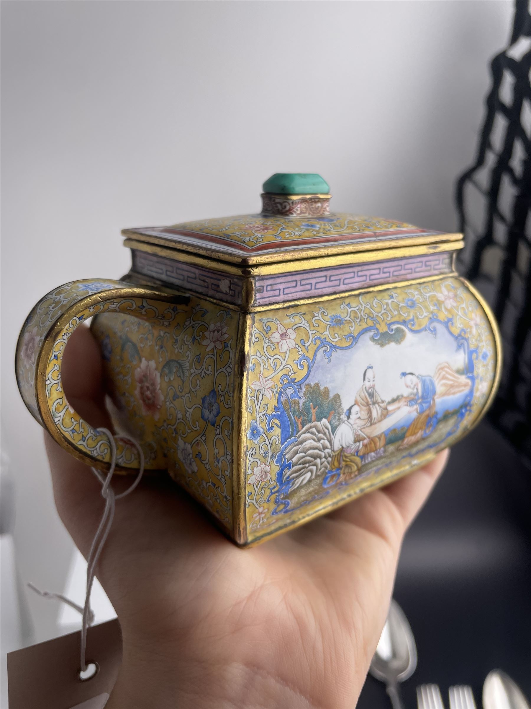 Chinese Qianlong enamel bombé shaped teapot, decorated with scenes of scholars examining a scroll and drinking on a yellow ground with various traditional floral and foliate motifs, the painted scene framed within trailing blue vine border, with Qianlong marks to base L15cm