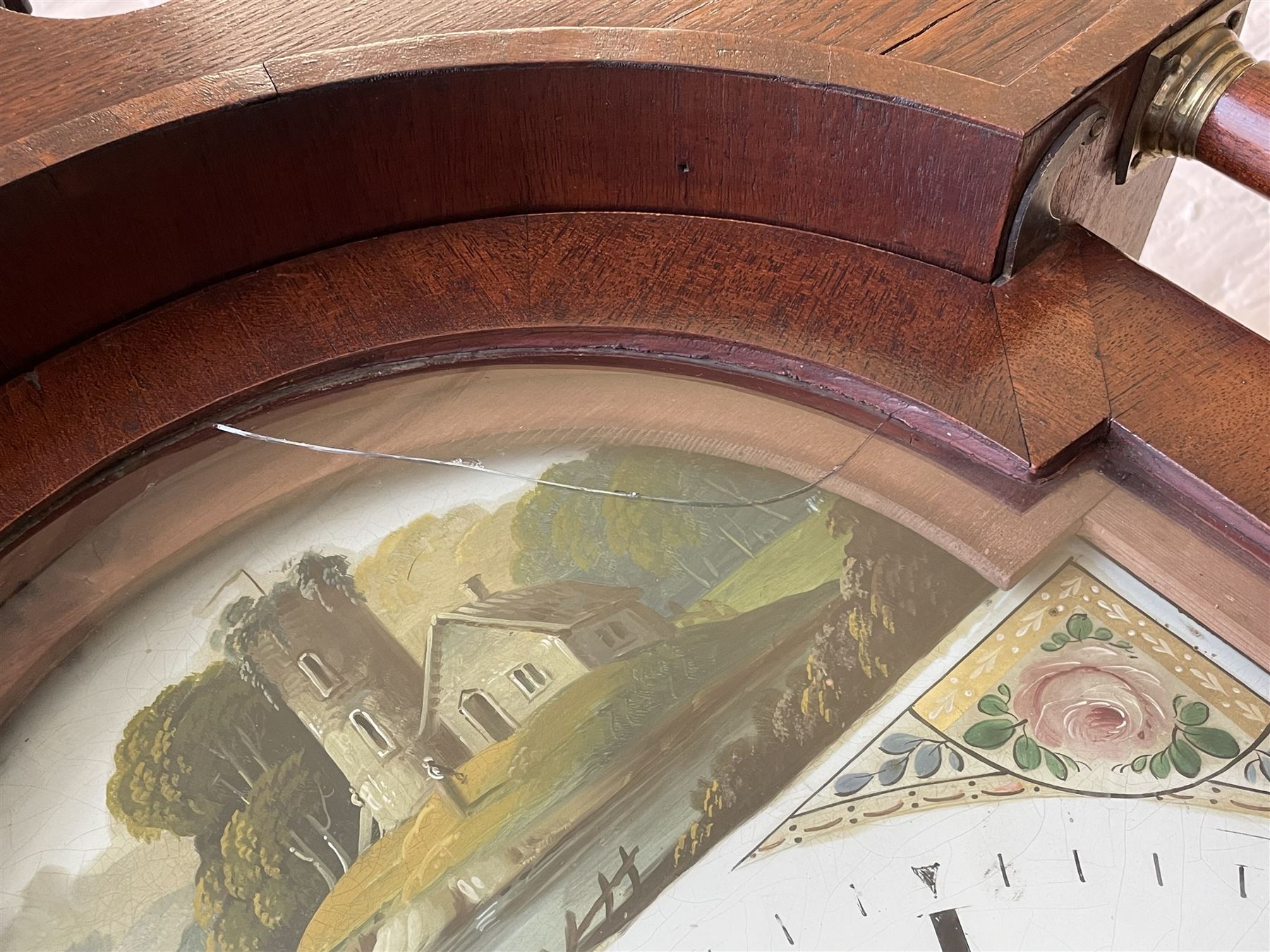 Thirty-hour oak cased longcase clock by  William Bancroft of Scarborough circa 1830, with a swan’s neck pediment, brass patera and three brass spire and ball finials, stepped break arch hood door flanked by plain pillars with brass capitals, trunk with a full length door and curved arch top, on a plain square plinth with bracket feet, painted break arch dial with roman numerals and quarter hour Arabic’s, date recorder (anti clockwise) and matching brass hands, arch painted with a rural scene depicting a ruined tower and cottage with depictions of flowers to the spandrels, dial pinned directly to a chain driven countwheel striking movement, striking the hours on a bell. With weight and pendulum. The Bancroft family were prodigious Scarborough clockmakers during the 18th and 19th century, William Bancroft is recorded as working in Newborough Street from 1820 onwards. 


