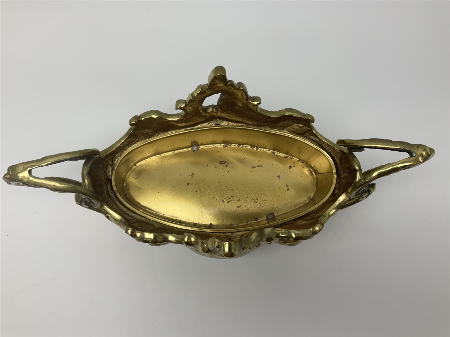 Ornate brass centrepiece, with twin handled vase upon a mirrored base, with floral and scrolling decoration, H23cm 