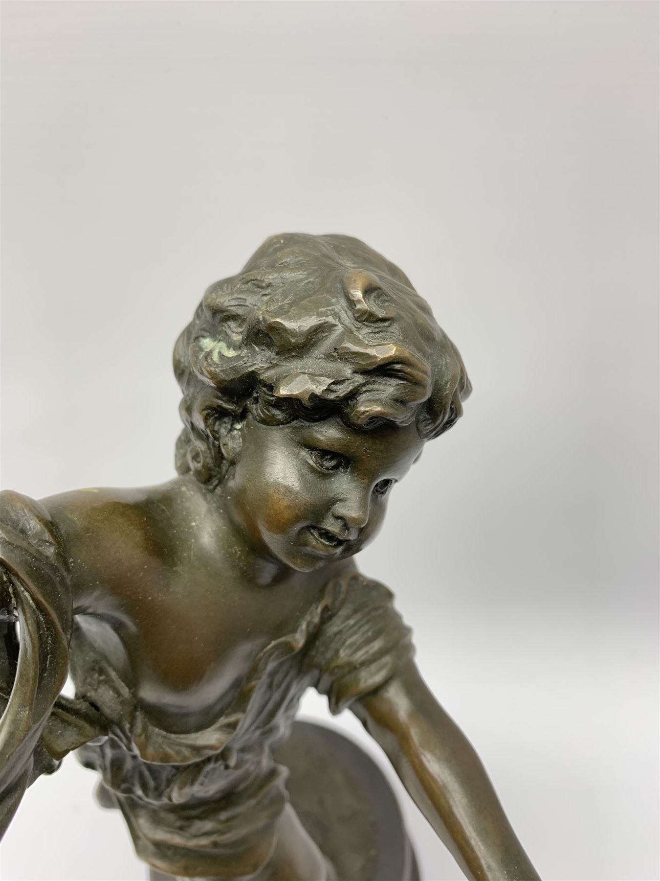After E Plat, bronze modelled as a dancing child, signed E. Plat, upon cylindrical black marble base, H40cm