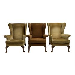 Parker Knoll - pair mid-20th century 'Penhurst' wingback armchairs, upholstered in dark olive green fabric, with foliate patterned textured seat cushions on cabriole front supports; with another in tan foliate patterned fabric (3)