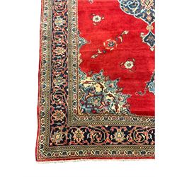 Persian Kashan crimson ground rug, the field decorated with interlacing medallion, floral design spandrels, guarded border with scrolling design decorated with stylised plant motifs
