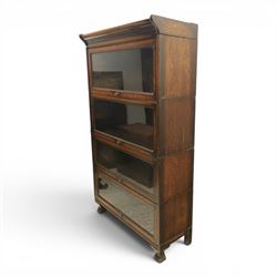 Harris Lebus - oak barrister stacking bookcase, four tier design with glazed fronts with brass knobs, raised on claw and ball feet