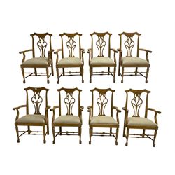 Set eight light oak Chippendale design carver dining chairs, shaped cresting rail with pierced and scrolled splat backs, upholstered seats with scrolling arm terminal, chamfered supports united by stretchers with pad feet