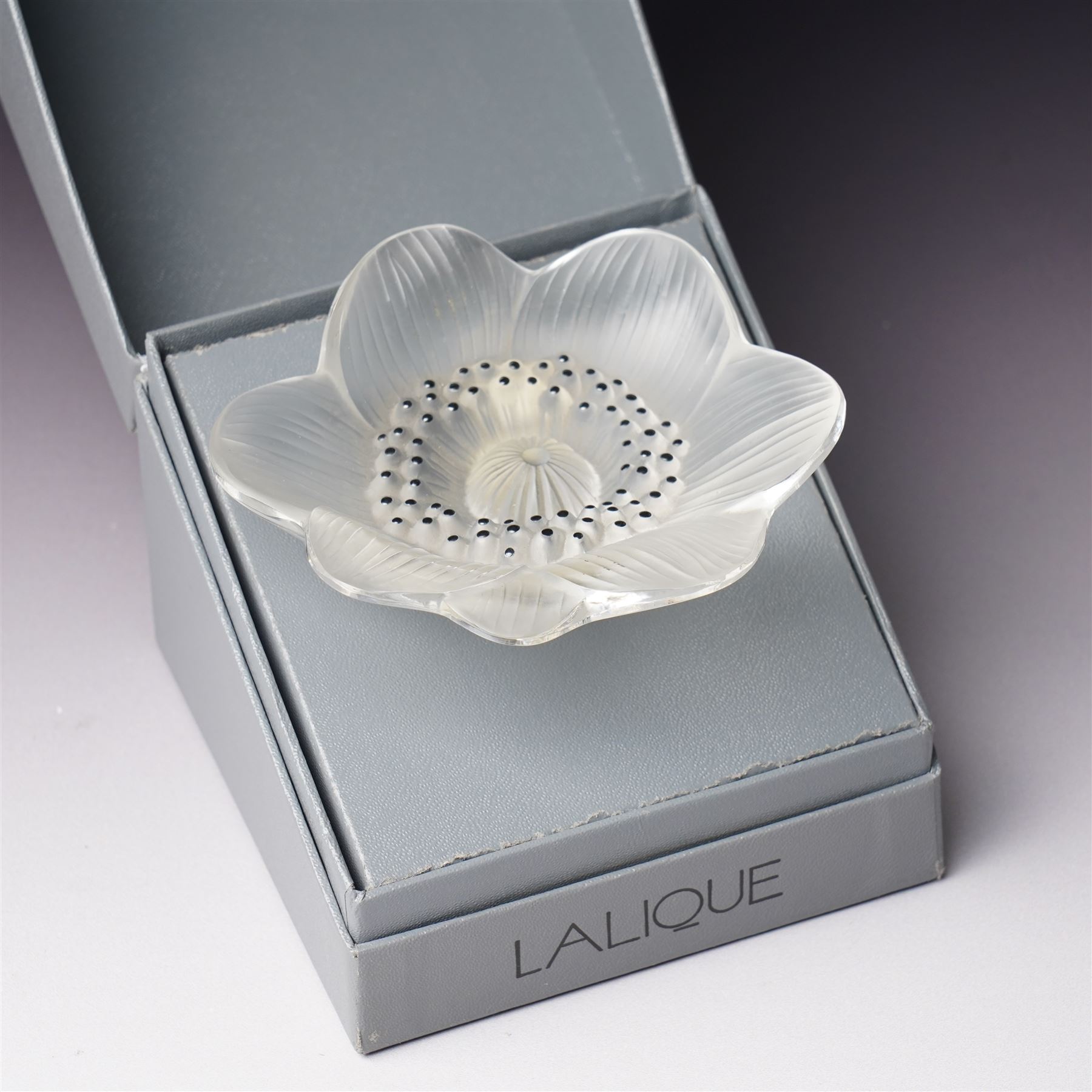 Lalique Lions Head glass ashtray and an 'Anemone' flower, both marked Lalique, France and boxed (2)