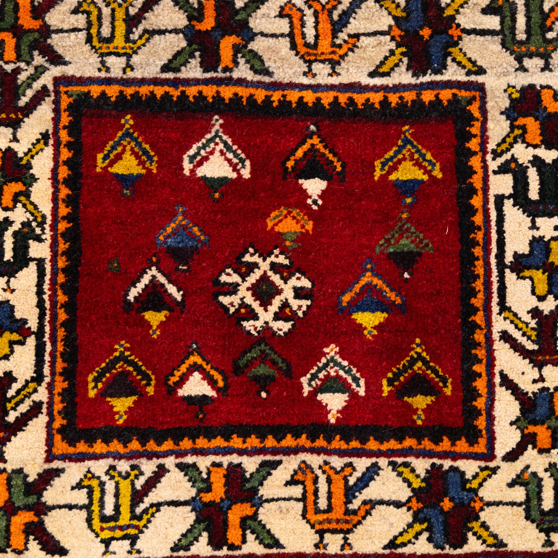 South West Persian Qashgai saddlebag, (Khorjin) saddlebag, comprising two pile-woven panels joined by a flatweave underside, each decorated with madder-red field filled stylized geometric motifs and hooked devices, enclosed by contrasting ivory borders populated with tribal figures and abstract forms