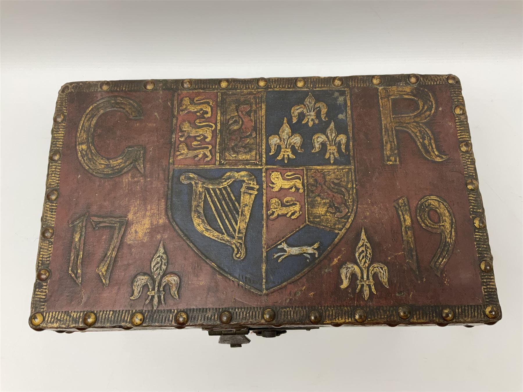 20th century box, decorated in faux leather with the royal coat of arms and GR 1719 to hinged cover, with fleur-de-lis, lion, crown and rose motifs throughout and studs to all edges, opening to reveal a purple velvet interior containing three removable wooden trays, H18.5cm