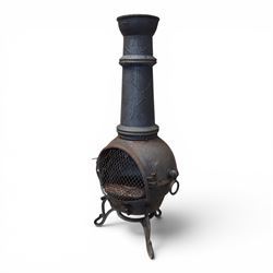 Cast iron garden chiminea, with mesh front spark guard, flue chimney on three splayed legs, finished in black.