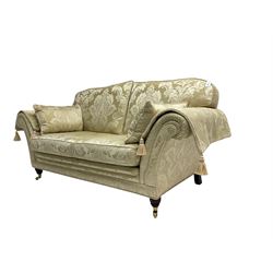 Steed Upholstery - two seat traditional shaped sofa, upholstered in cream fabric with scrolling foliate pattern, on turned front feet with brass castors, with side cushions and arm covers