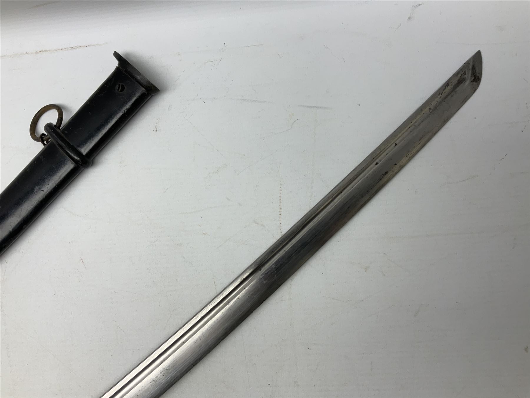 WW2 Japanese Army NCOs sword - katana, the 69.5cm slightly curving fullered blade numbered 14656; arsenal markings stamped near the habaki on the handle; brass tsuba and black painted metal hilt cast to simulate cord bound fish skin; in black painted steel scabbard with single suspension ring L96cm overall