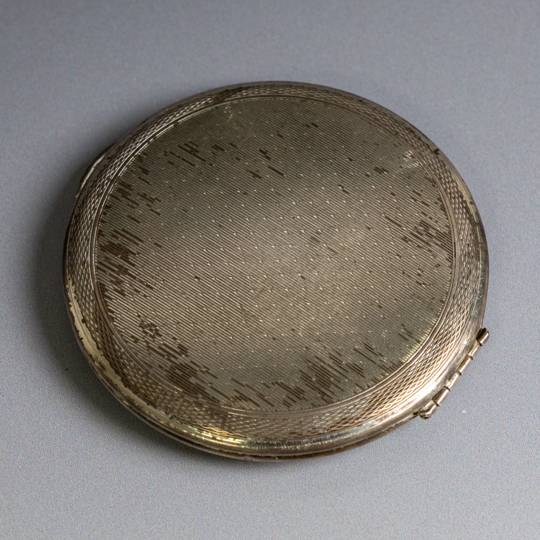Two silver compact mirrors, comprising a Kigu powder compact with engine turned decoration and a compact mirror with floral decoration, both hallmarked