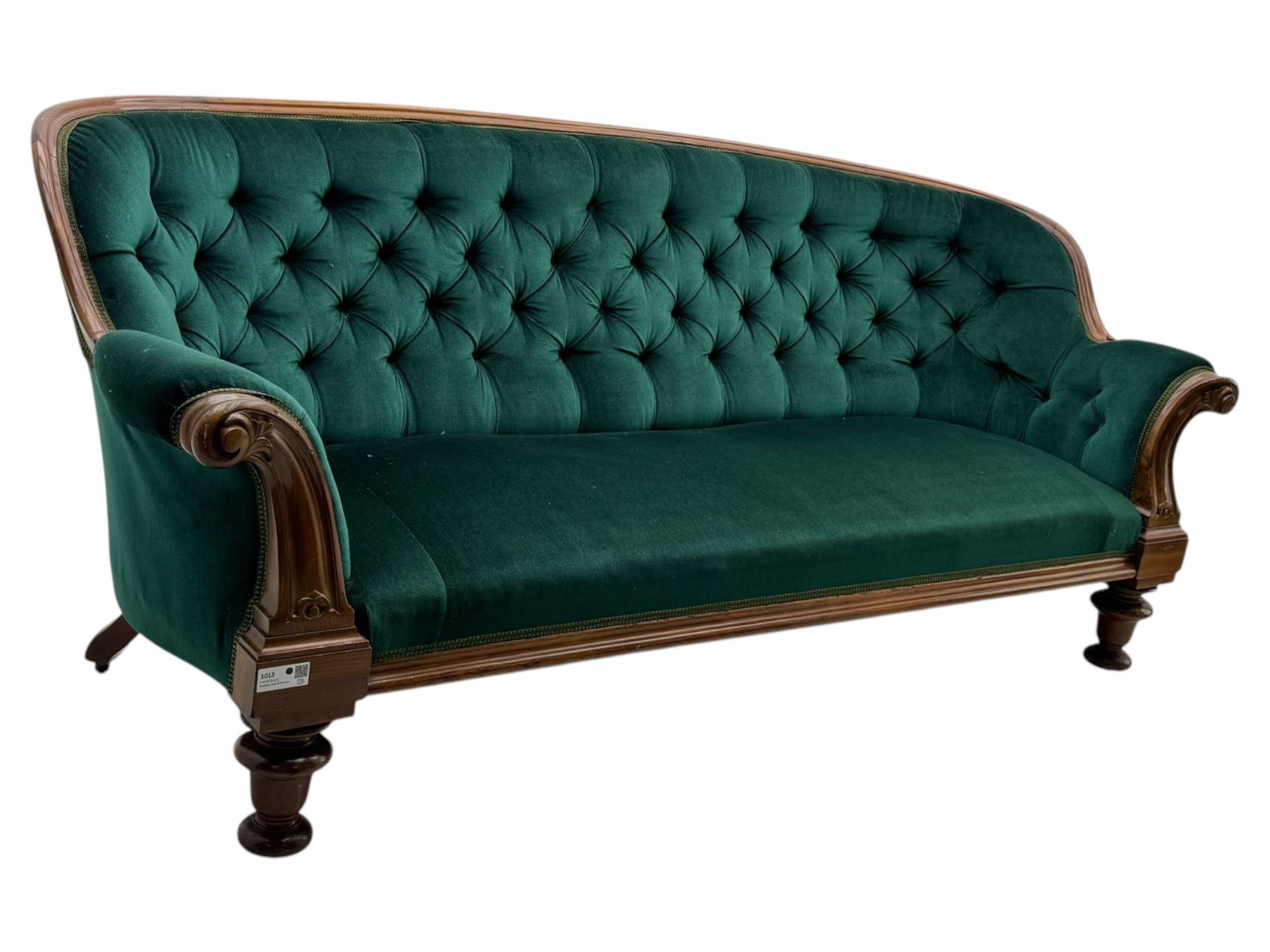 Victorian mahogany settee, upholstered in green buttoned fabric, moulded frame and scroll carved arm terminals, turned supports on castors