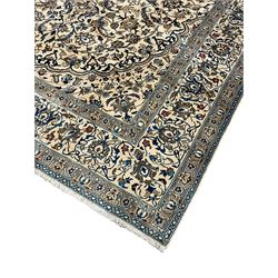 Persian ivory ground carpet, overall floral pattern with central rosette medallion, the field decorated with interlaced leafy branches and stylised plant motifs, guarded repeating border with repeating design