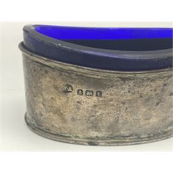 Modern two piece silver cruet set, comprising pepper shaker and open salt, each with shaped rims and upon four pad feet, hallmarked William Suckling Ltd, Birmingham 1962, together with an early 20th century silver open salt, of oval form, hallmarked William Aitken, Birmingham 1918