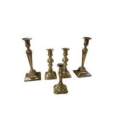 Three partial sets of brass weights, and two pairs of brass candlesticks