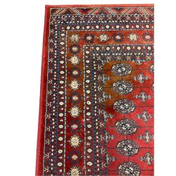 Persian Bokhara design rug, red ground and decorated with five rows of Gul motifs, geometric design border decorated with stylised motifs