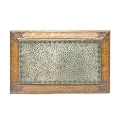 Arts and Crafts oak stand by Arthur Simpson of Kendal, of rectangular form with central hammered pewter panel, surrounded by a border with carved foliate corners, upon two bar supports, bearing label detailed 