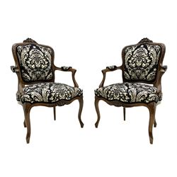 Pair 19th century French walnut Fauteuil open armchairs, the cresting rail carved with shell and flower head motifs, upholstered in foliate and cornucopia patterned fabric, leaf carved cabriole supports and serpentine apron